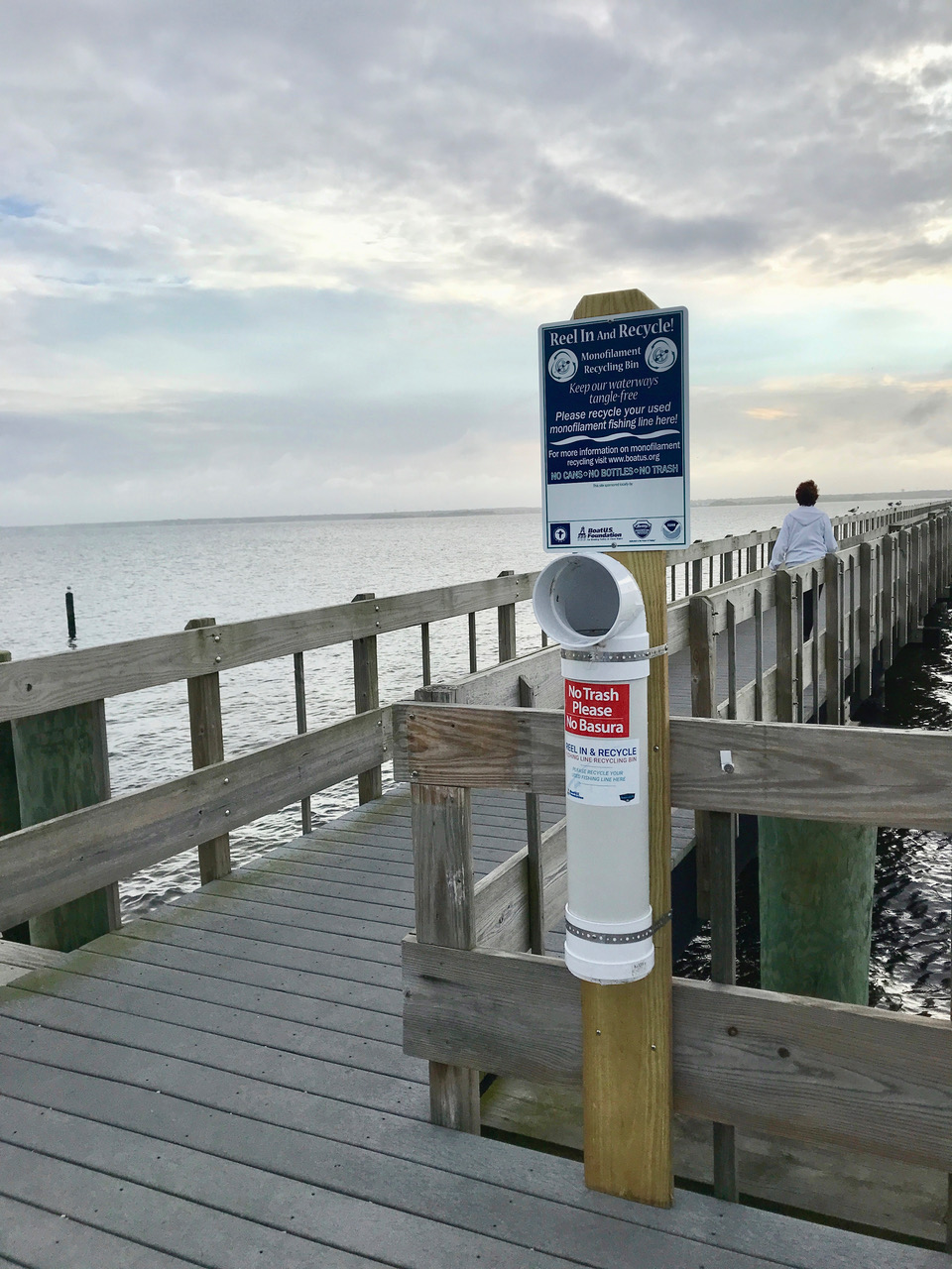 A no fishing sign posted on a pier overlooking the ocean